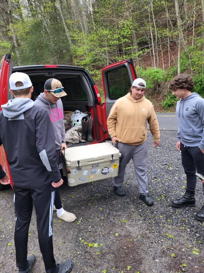 Ben Smith and Waylon Dauber unload the cooler of brook trout while Pence Kaiser and Grant Vilello prepare to help stock the fish. 