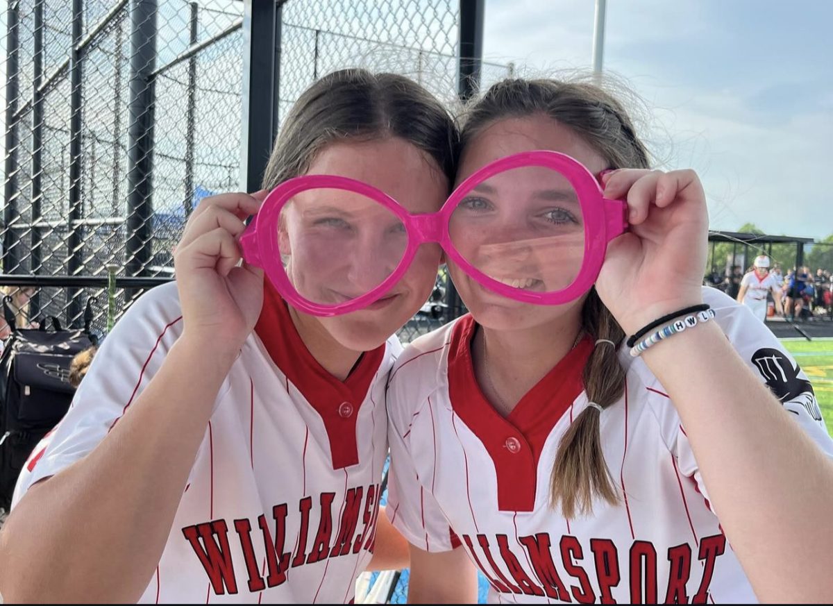 Brenna Beck and Abbigail Robertson pose for a picture in the "homerun glasses", a team tradition this year. 